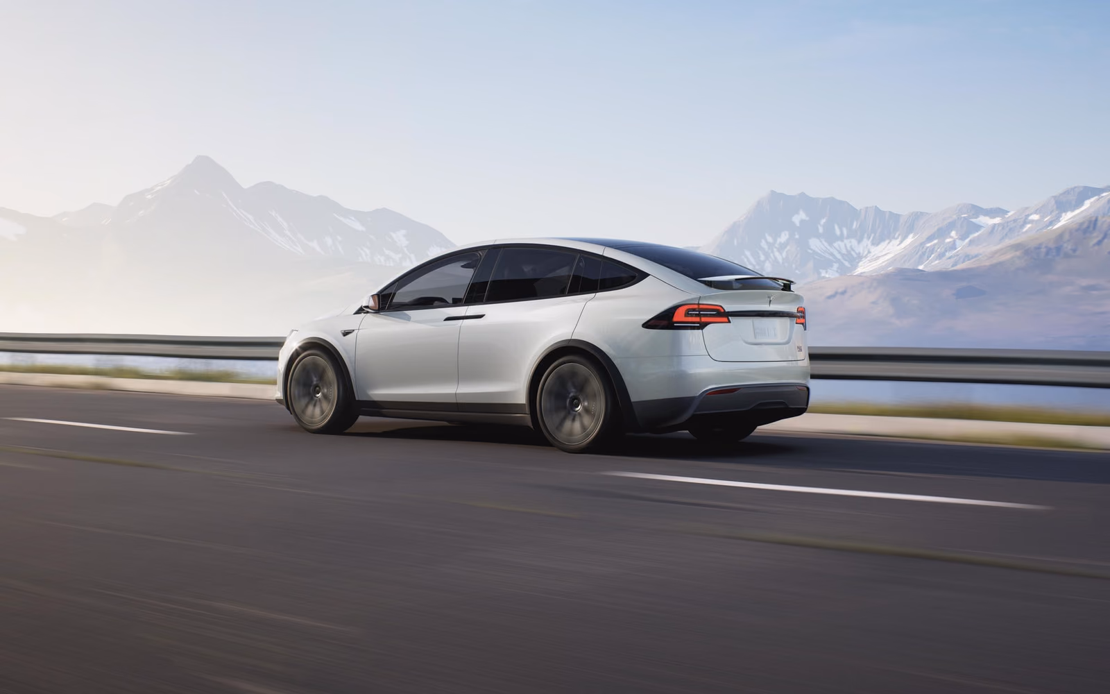 Tesla Model X на горной дороге, вид спереди в три четверти
