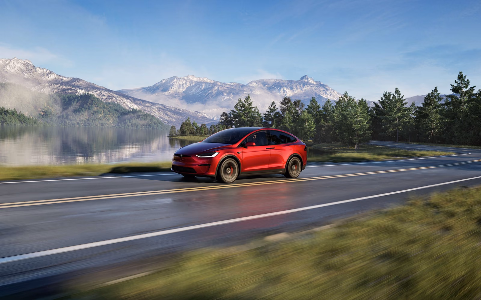 Красная Tesla Model X в движении у озера