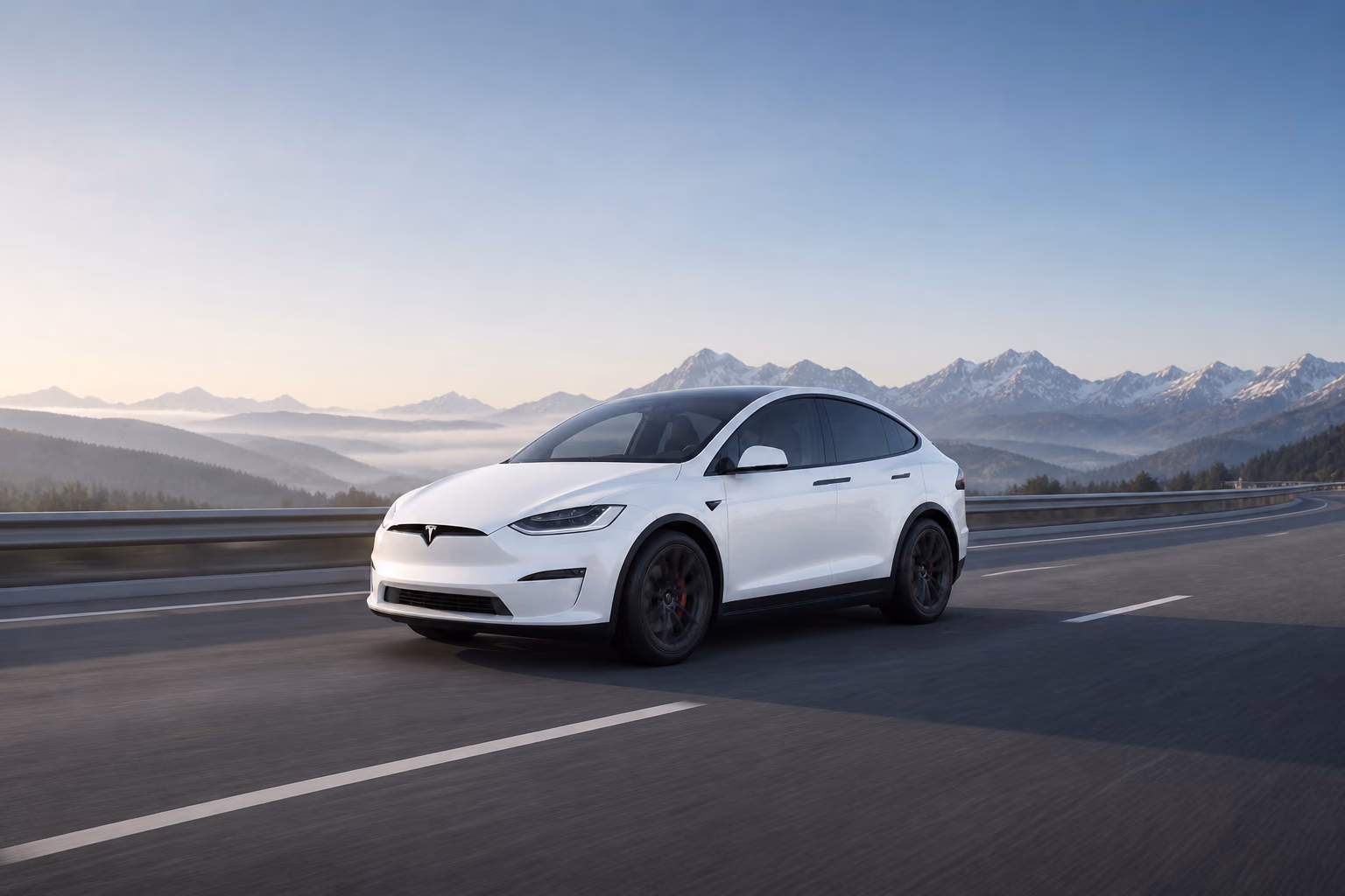 Белая Tesla Model X на многополосной горной трассе