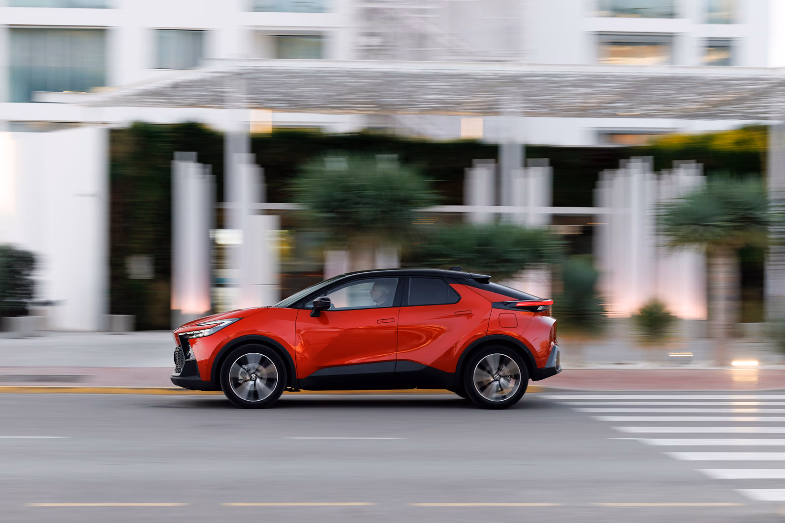 Красный Toyota C-HR второго поколения в профиль