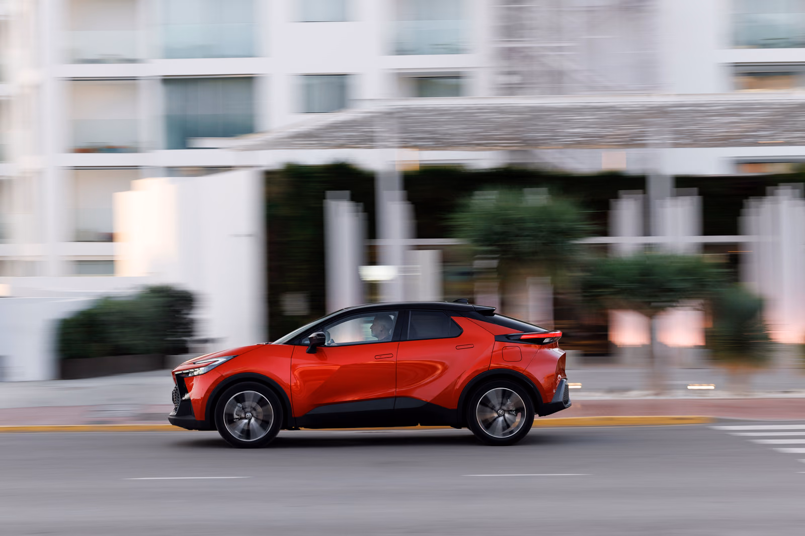 Красный Toyota C-HR на городской дороге