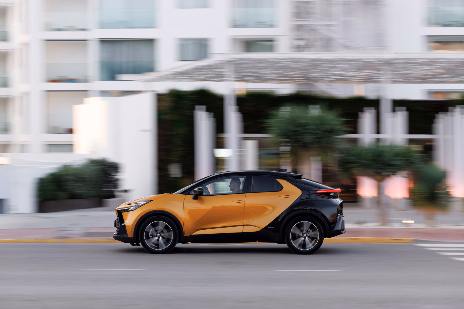Золотистый Toyota C-HR в движении