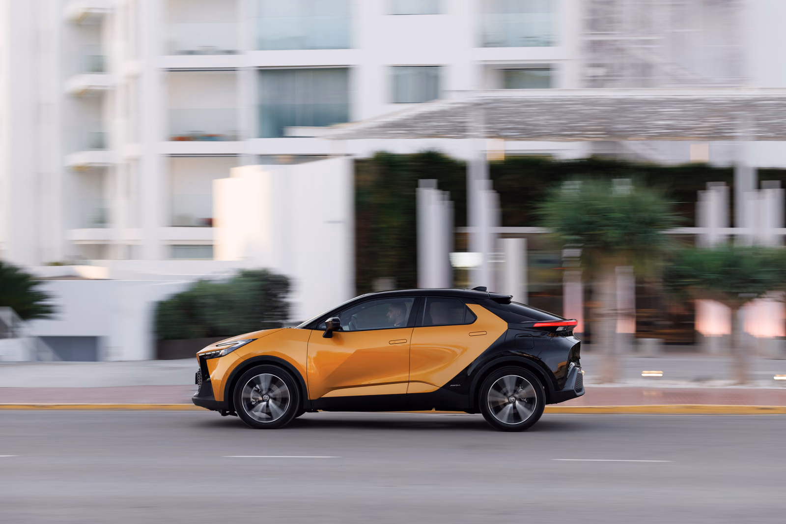 Золотистый Toyota C-HR второго поколения сбоку