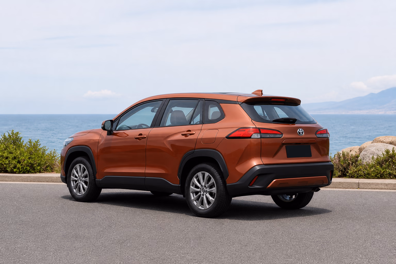 Медная Toyota Corolla Cross на пустой прибрежной дороге