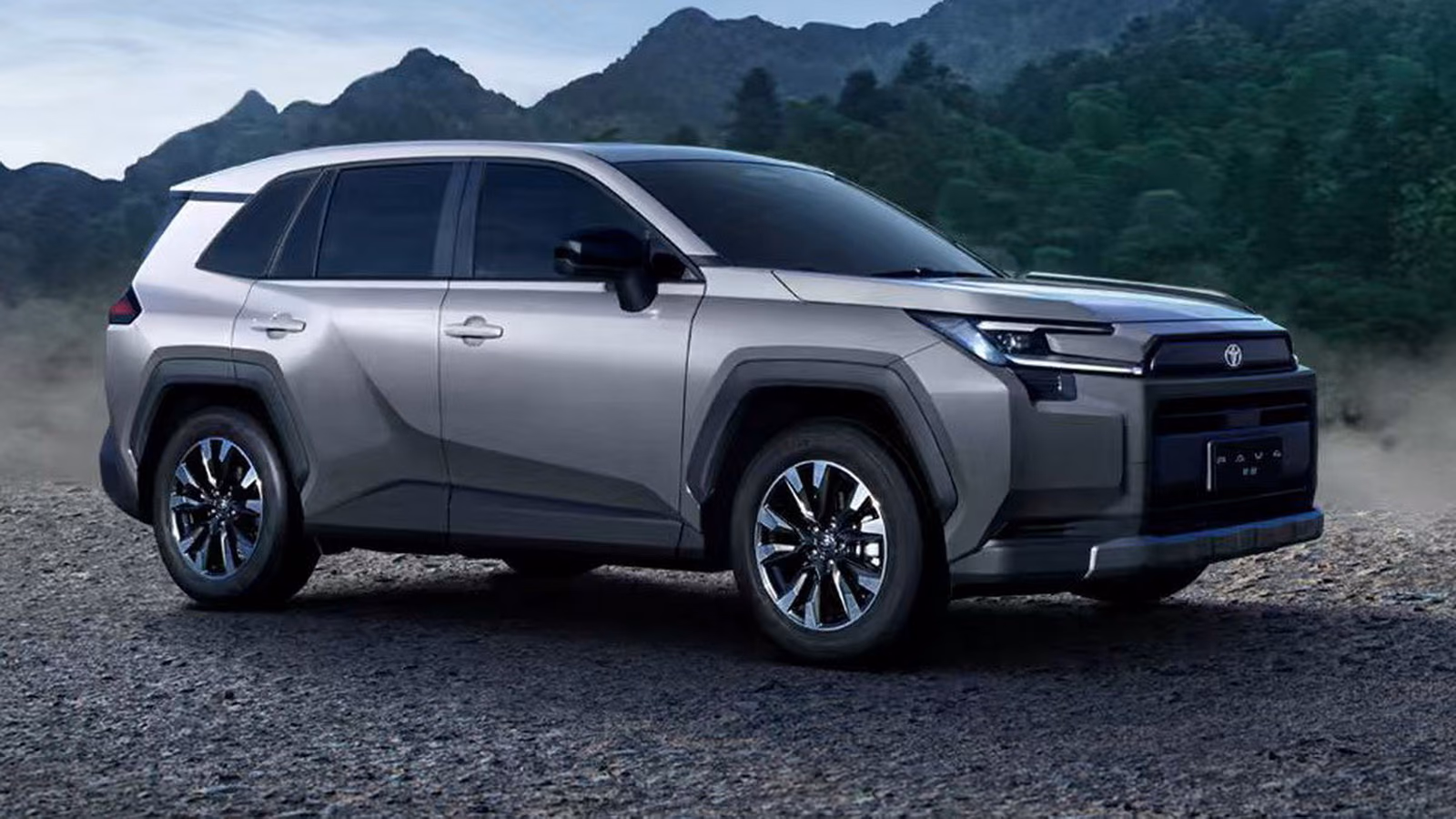 Toyota RAV4 в сером цвете, вид спереди сбоку на фоне гор